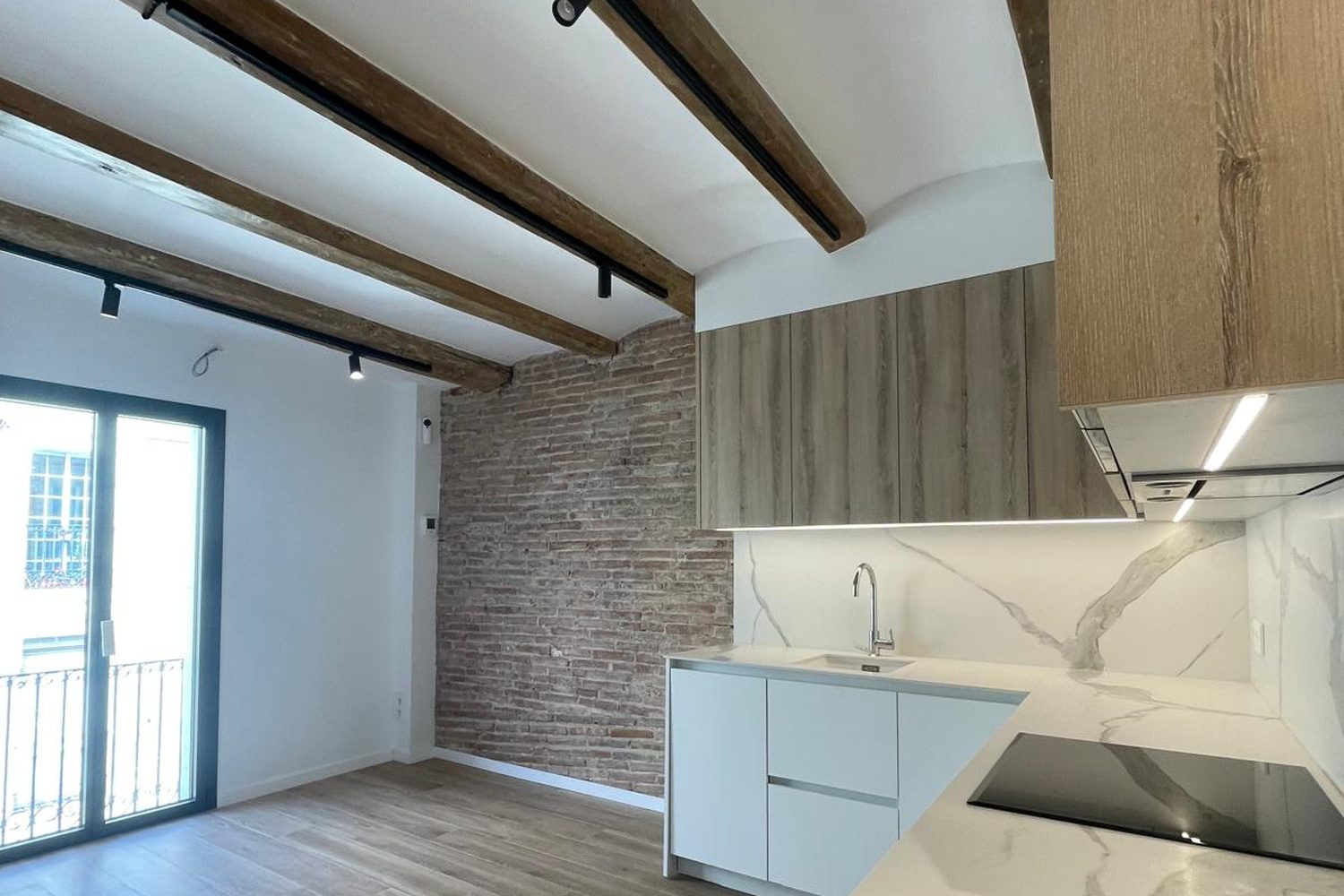 Salón con cocina abierta y vigas de madera — después de la obra